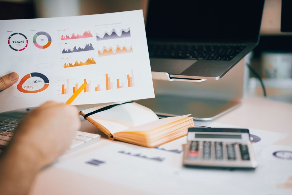Hands reviewing charts on a laptop to track local SEO results and Google Map Pack rankings
