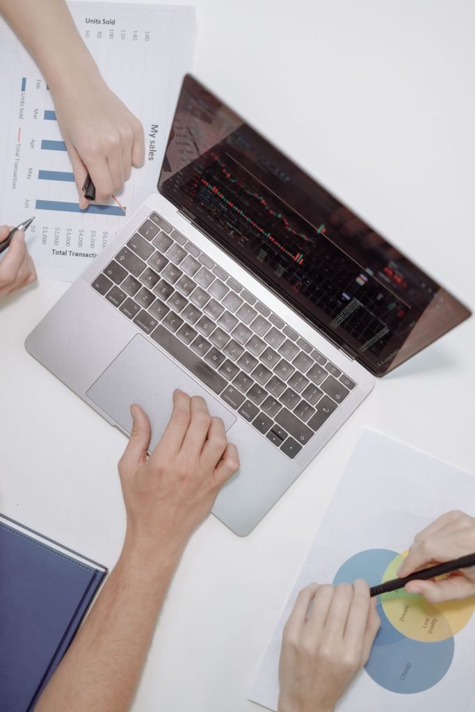 Team discussing financial charts on a laptop to prepare for open banking in Canada