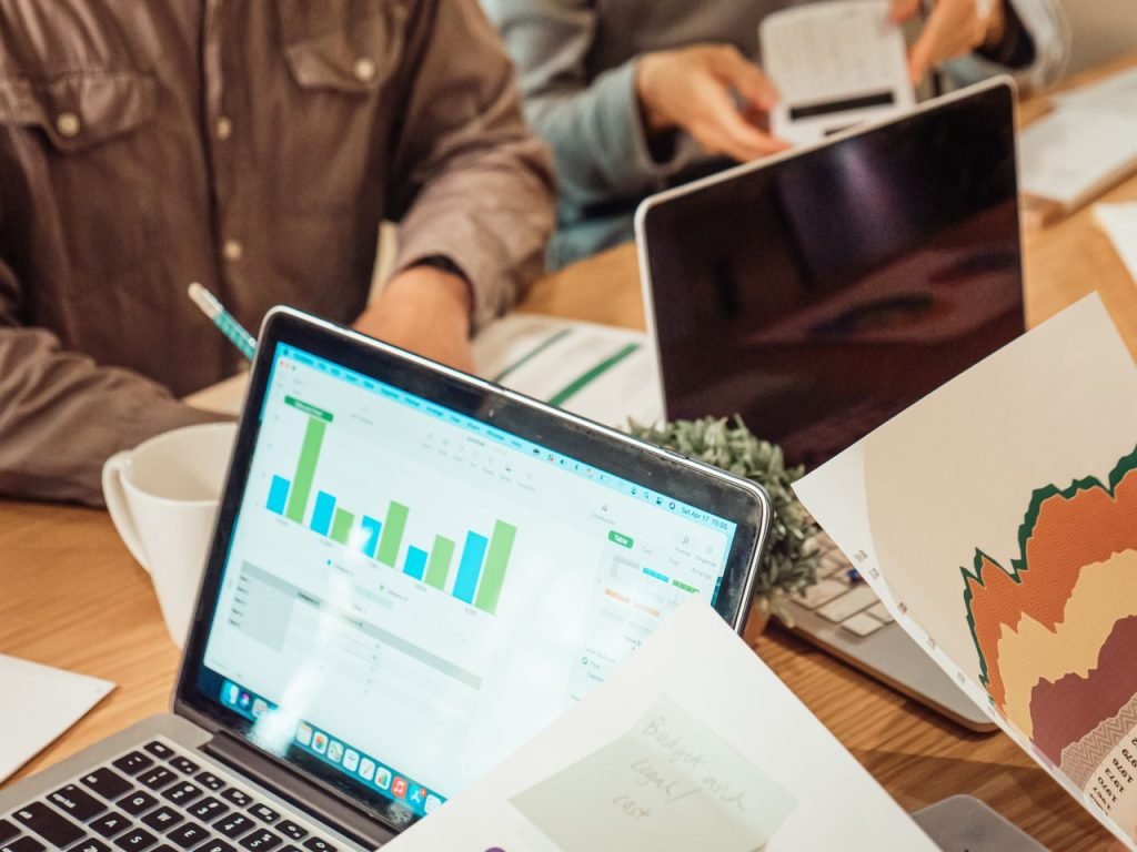 Founders planning an AI-native SaaS MVP with laptops, graphs and paperwork